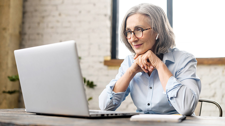 Older woman sat at computer wondering if "Is lens replacement the same as cataract surgery"